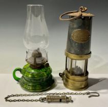 A miner's lamp, J H Naylor, Wigan; an ACME Police or Fire whistle; a green glass oil lamp (3)