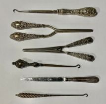 Two silver handled glove stretchers; two silver handled button hooks and a paper knife, 334g gross