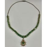 A gold plated necklace, set with a strand of graduated faceted oval emeralds, suspended with a