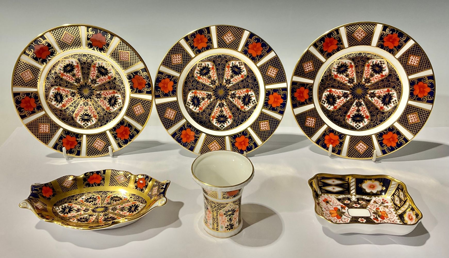 A set of three Royal Crown Derby Imari 1128 pattern tea plates; a shaped oval trinket tray with