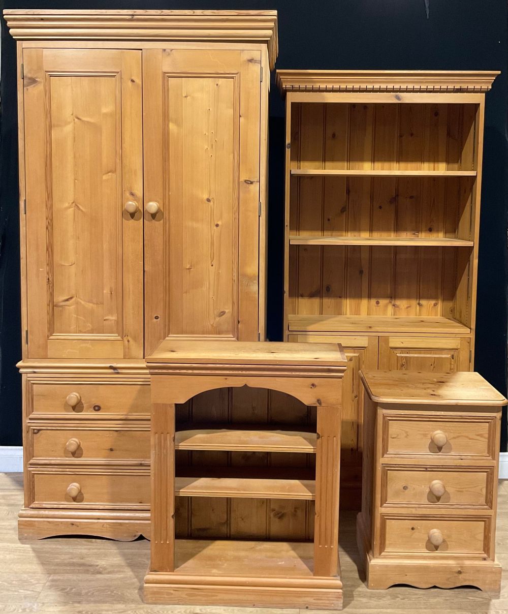 A pine double wardrobe with three long drawers, 198cm high, 98cm wide, 62cm deep; a pine bookcase