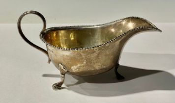 A George V silver sauce boat, scroll handle, hoof feet, Birmingham 1928, *111g gross