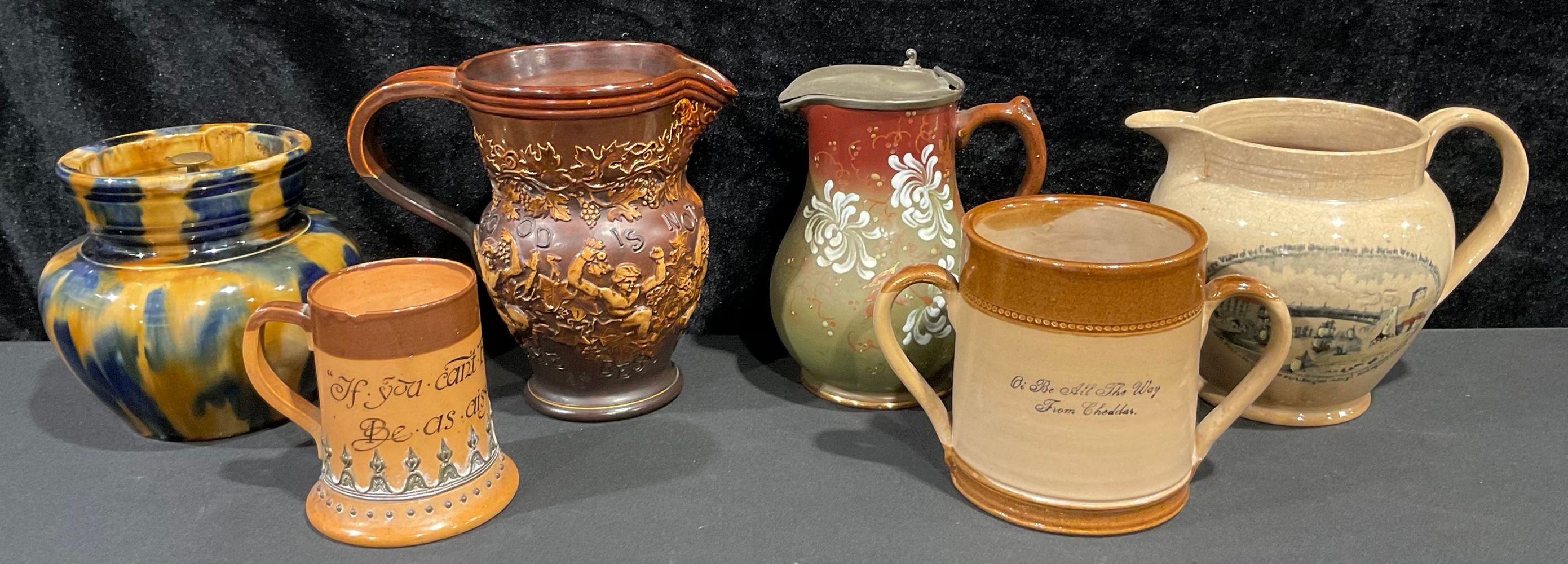 A Royal Doulton salt glazed jug, decorated in relief with Bacchanalian revellers, inscribed 'Good Is