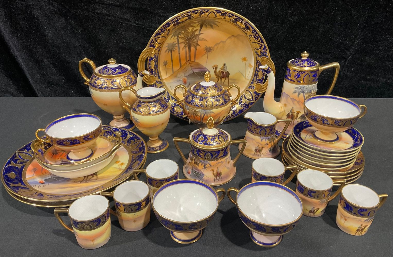 A Noritake coffee set painted with Egyptian desert scenes, palm trees, rider on camel back and