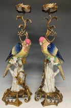 A pair of reproduction Meissen style candlesticks, modelled as parrots, gilt metal mounted, 55cm