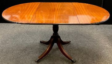 A 19th century style reproduction mahogany drop-leaf dining table, pedestal base, with brass lion-