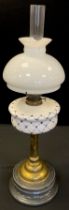 An early 20th century brass oil lamp, blue and white ceramic reservoir, white glass shade, 71cm