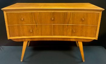 An Alfred Cox style, mid century design walnut and beech Dressing table, inverted bow-front, three