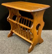 An Ercol medium tone elm Canterbury / magazine rack side table, rounded rectangular top, pierced