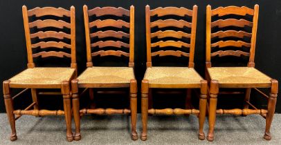 A set of four oak ladder-back dining chairs, early 19th century style, rush seats, turned stretchers