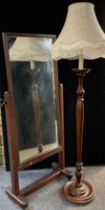 A mid 20th century mahogany cheval mirror, 156cm high x 67.5cm wide; a mahogany standard lamp, (2).