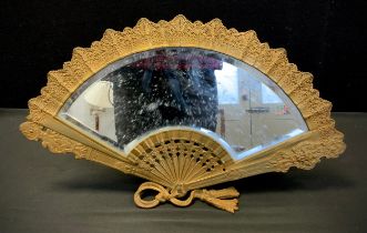 A gilt metal framed table top mirror, shaped as a fan, arched bevelled plate, 28cm high, 48cm wide.