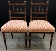 A pair of Edwardian carved Rosewood bedroom chairs, spindle backs, 84cm high, (2).