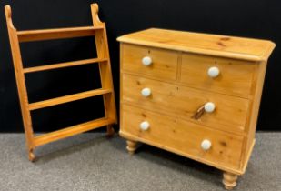 A pine chest of drawers, two short over two long drawers, ceramic handles, turned feet, 83cm high