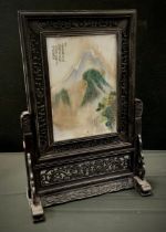A Chinese porcelain and carved wooden table screen, Traditional mountain landscape, 66cm high,