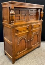 An oak court cupboard, turned decorative supports, with pair of small cupboard doors to top, the