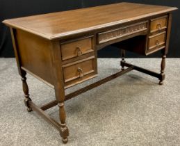 A dark oak desk / writing table, single long drawer to frieze, with pair of short drawers each side,