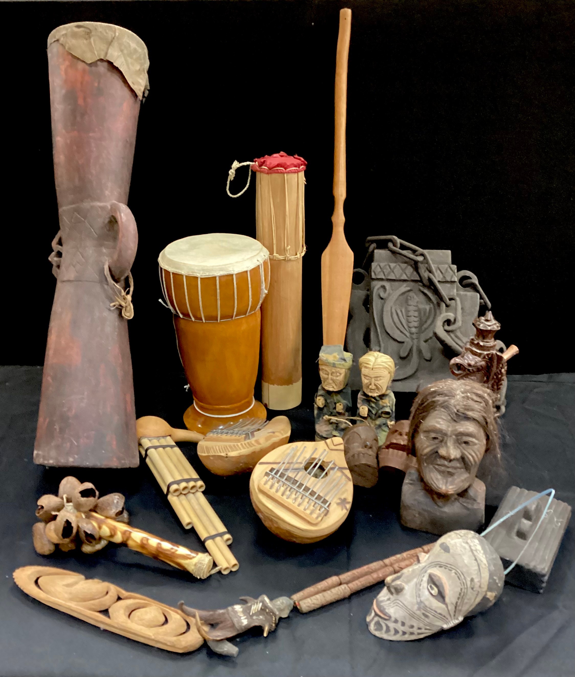 Tribal objects including; a 20th century wooden bitel bag, Kundu drum, carved dragon pipe, shell