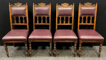 A set of four oak Art Nouveau carved dining chairs, stuffed over seats, turned fore legs (4)