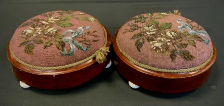 A pair of Victorian round footstools, beadwork tapestry cushioned tops, ceramic bun feet, each