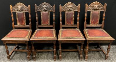 A set of four Victorian carved oak dining chairs, the top rail carved with a ‘Green-man’ style mask,