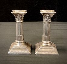 A pair of Edwardian silver Corinthian column candlesticks, weighted base, Sheffield 1908, 11.5cm