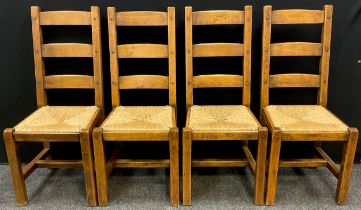 A set of four Griffiths style solid oak ladder back dining chairs, drop-in rush seats, pegged