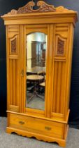 An Edwardian Satinwood wardrobe, carved swan-neck cornice, bevelled mirror to centre door, single