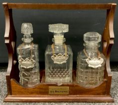 A three bottle mahogany tantalus by the Balvenie with cut glass decanter’s. 30cm high x 34cm wide