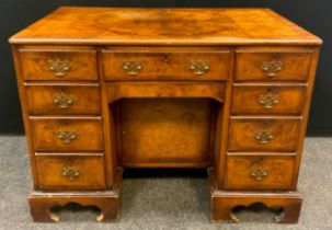 A George II style walnut and Burr walnut knee-hole desk, single drawer to frieze, above a ‘secret’