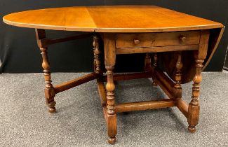 A Titchmarsh and Goodwin style oak drop-leaf dining table, 75cm high x 129.5cm x 73cm (181.5cm