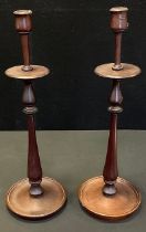 A pair of turned wooden candlesticks, circular bases, 48cm high (2)
