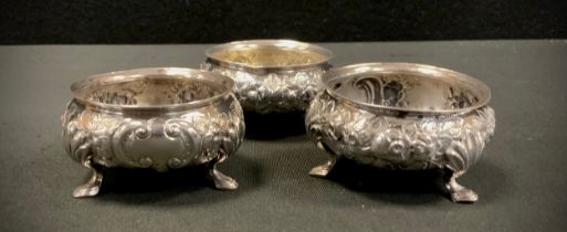 A set of three Victorian Provincial Exeter silver open table salts, embossed floral bodies, tripod