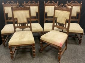 A set of six Victorian carved oak dining chairs, carved swan-neck top rails, upholstered back and