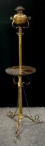 An early 20th century telescopic floor standing oil lamp stand, gilt metal scroll tri-pod feet and