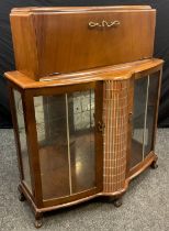 An Art Deco style 1950’s walnut veneered cocktail display cabinet, 114.5cm high x 94cm wide x 43cm