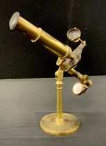 A 19th century brass monocular travelling microscope, slide action focus, screw off circular foot,