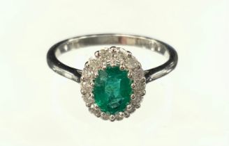 An emerald and diamond cluster ring, central emerald approx 0.86ct surrounded by fourteen round