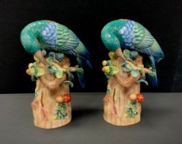 A pair of porcelain green exotic birds on tree stump, faux Sevres mark, 29cm high (2)