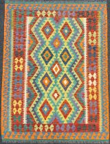 A Turkish Anatolian Kilim rug, knotted with a traditional design, in bright colours, red, orange,