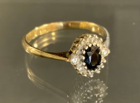 A sapphire and diamond ring, central oval deep blue sapphire approx 0.45ct, sixteen round