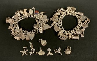 Jewellery - two silver charm bracelets suspending over fifty assorted silver and white metal charms,