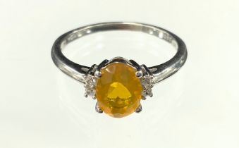 A fire opal and white sapphire ring, oval cut fire opal aprox 1.0ct, between pair of white