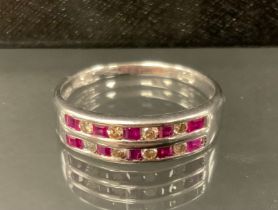 A ruby and diamond ring, with two rows of alternating square step cut rubies and round brilliant cut