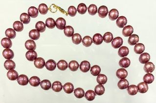 A dark pinky purple cultured pearl necklace, 41cm long, unmarked yellow metal clasp.
