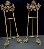 A pair of gilt metal baroque style easel stands, 82cm high (2)