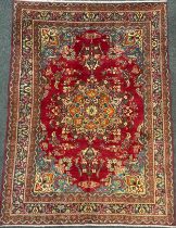 A North West Persian Tabriz carpet, hand-knotted with elaborate Central medallion, within a field of