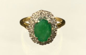 An emerald and diamond cluster ring, central oval emerald approx 1.30ct, surrounded by twelve