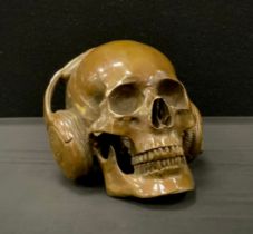 A bronzed metal model of skull wearing headphones,18cm high