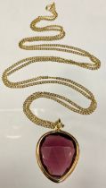 A yellow metal curb link necklace, stamped 333, 9.1g, suspending a faceted heart amethyst glass